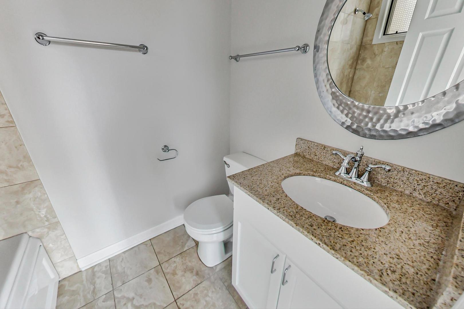 1826 West Rice Street, Unit 2 Chicago, IL 60622 - Photo 12 of 24 a bathroom with a granite countertop sink and a mirror