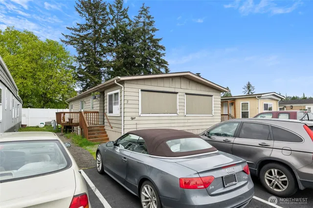 a front view of a house with cars parked