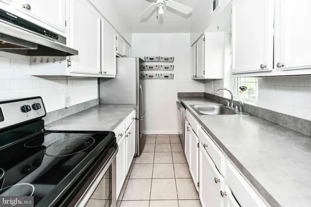 a kitchen with stainless steel appliances a sink stove and cabinets