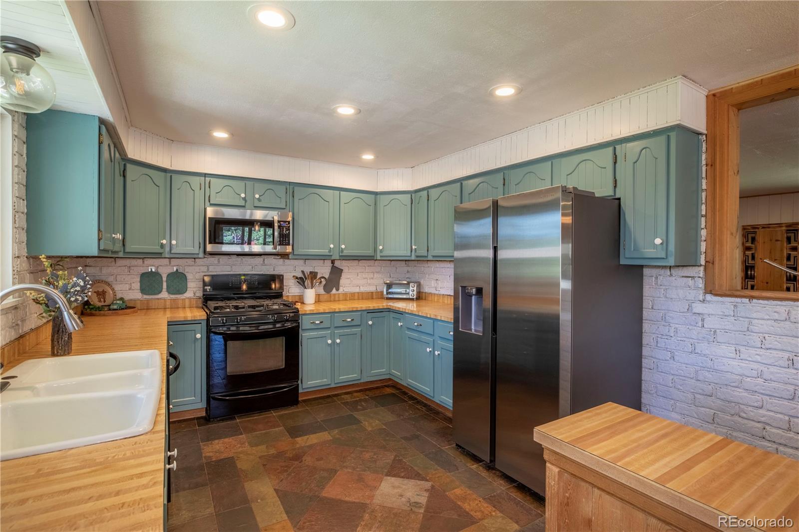 12322 South Wamblee Valley Road Conifer, CO 80433 - Photo 20 of 37 a kitchen with stainless steel appliances granite countertop a refrigerator a stove and a sink