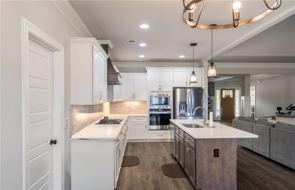 712 Fleeting Way Monroe, GA 30655 - Photo 6 of 29 a kitchen with a sink stainless steel appliances a counter top space cabinets and a ceiling fan