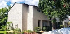 a view of a house with a yard and tree s