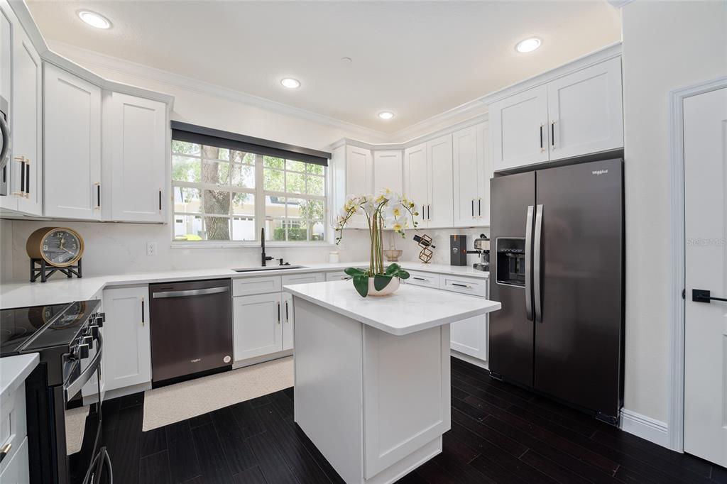 152 Riggings Way Clermont, FL 34711 - Photo 21 of 68 a kitchen with stainless steel appliances a sink a stove a refrigerator cabinets and a window