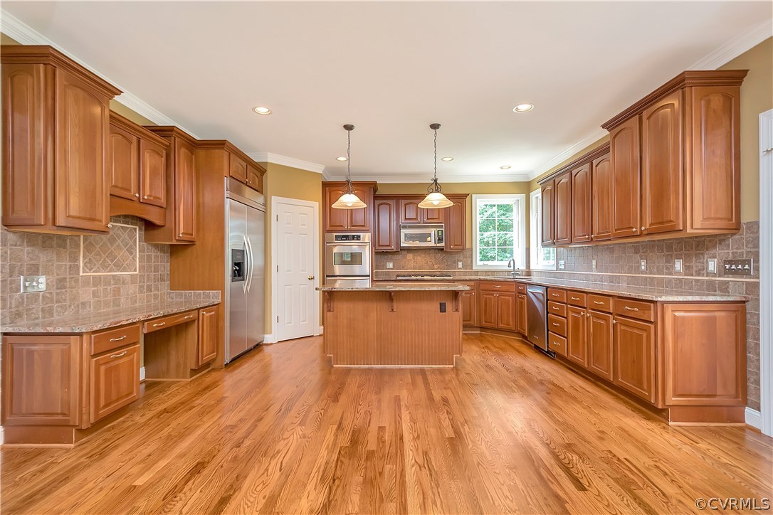 10705 Chatham Ridge Way Spotsylvania, VA 22551 - Photo 11 of 40 a large kitchen with stainless steel appliances wooden floors and wooden cabinets
