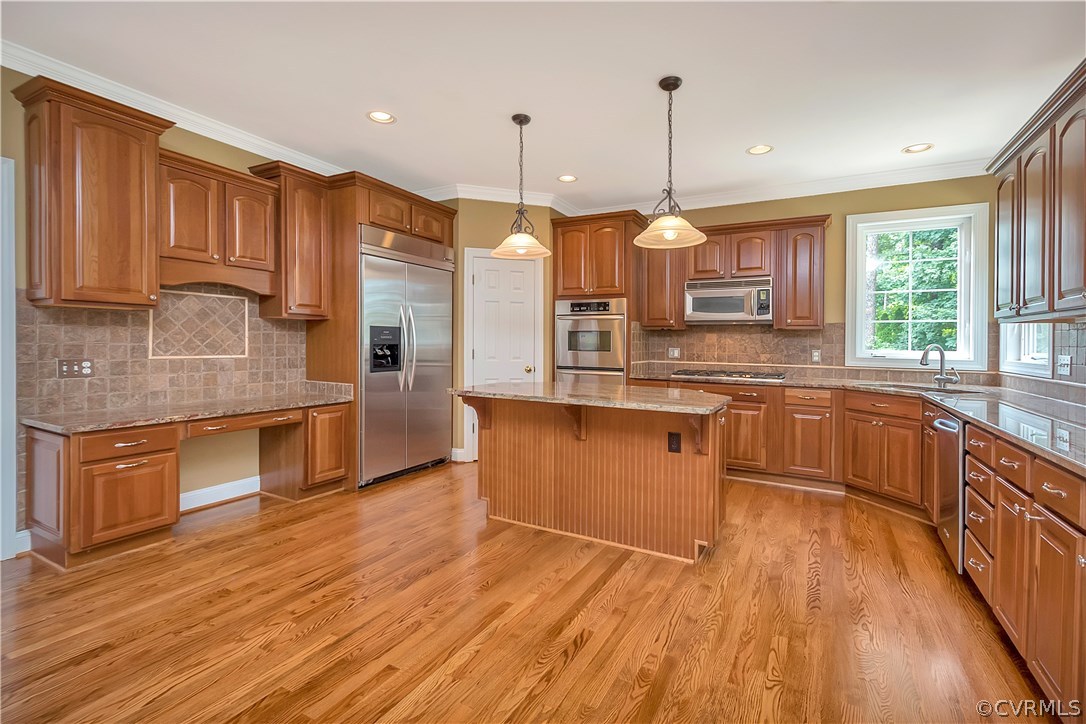 10705 Chatham Ridge Way Spotsylvania, VA 22551 - Photo 12 of 40 a kitchen with stainless steel appliances granite countertop wooden floors wooden cabinets a sink and a window