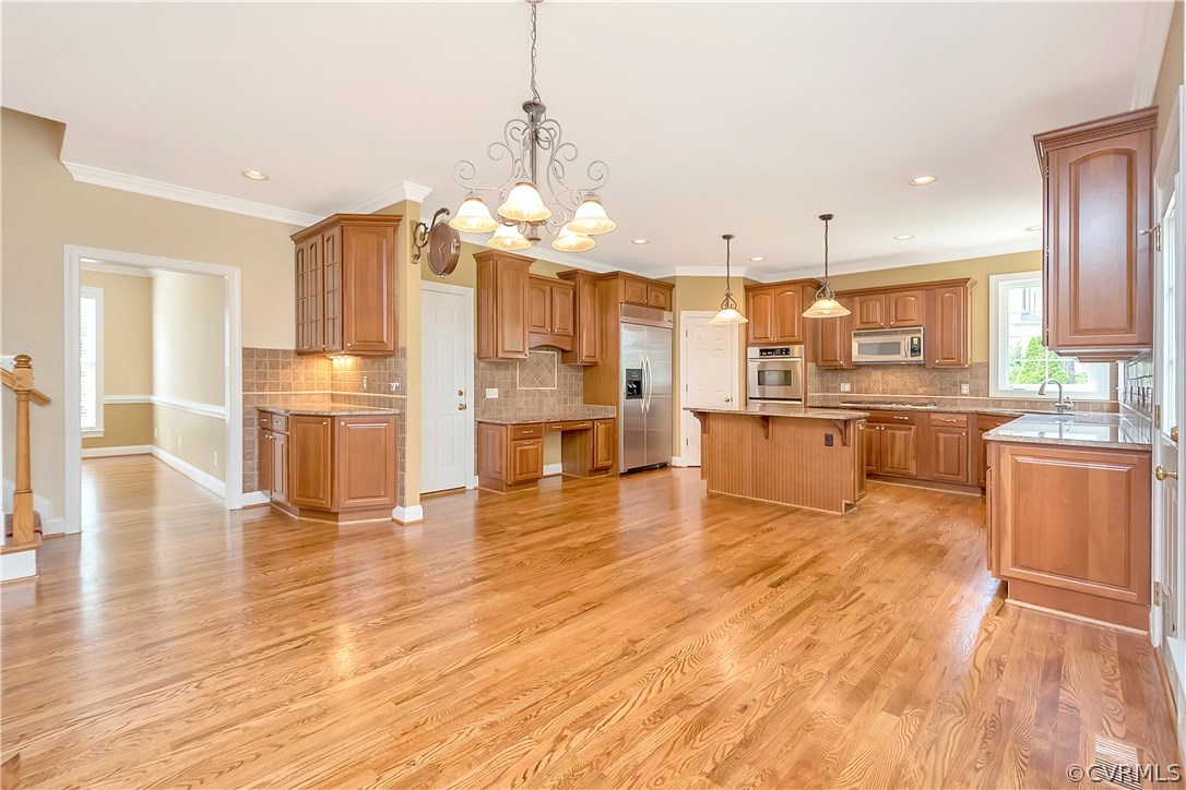 10705 Chatham Ridge Way Spotsylvania, VA 22551 - Photo 9 of 40 a large kitchen with stainless steel appliances kitchen island granite countertop wooden floors and a view of living room