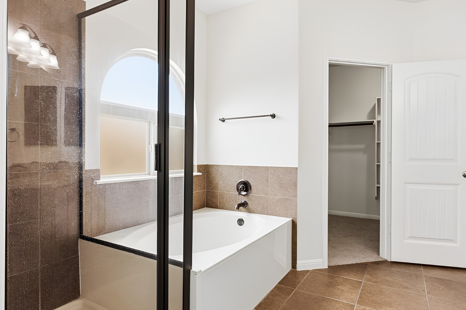 304 Santa Maria Street Georgetown, TX 78628 - Photo 18 of 37 A well-appointed bathroom features a combined shower and soaking tub, with an arched window allowing natural light.