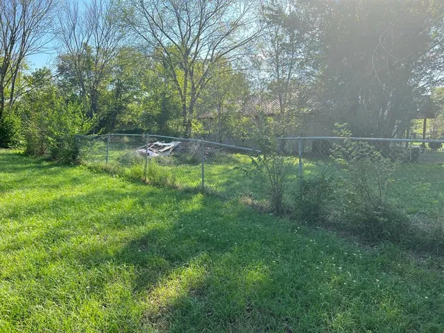 a backyard of a house with lots of green space and lake view