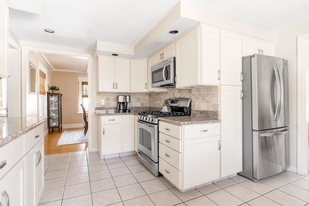60 High Street Needham, MA 02494 - Photo 12 of 32 a kitchen with stainless steel appliances granite countertop a refrigerator and a stove top oven
