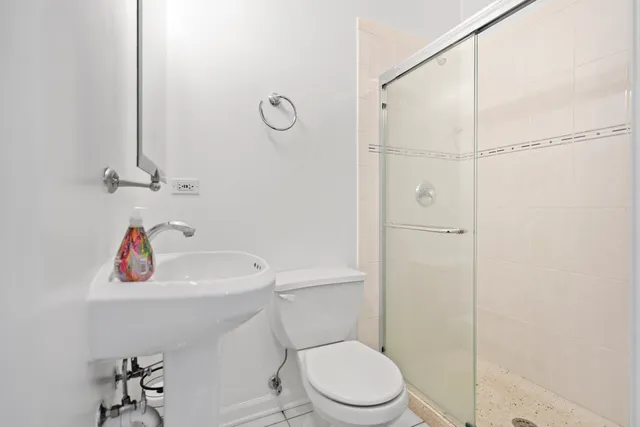 a bathroom with a sink a toilet and shower