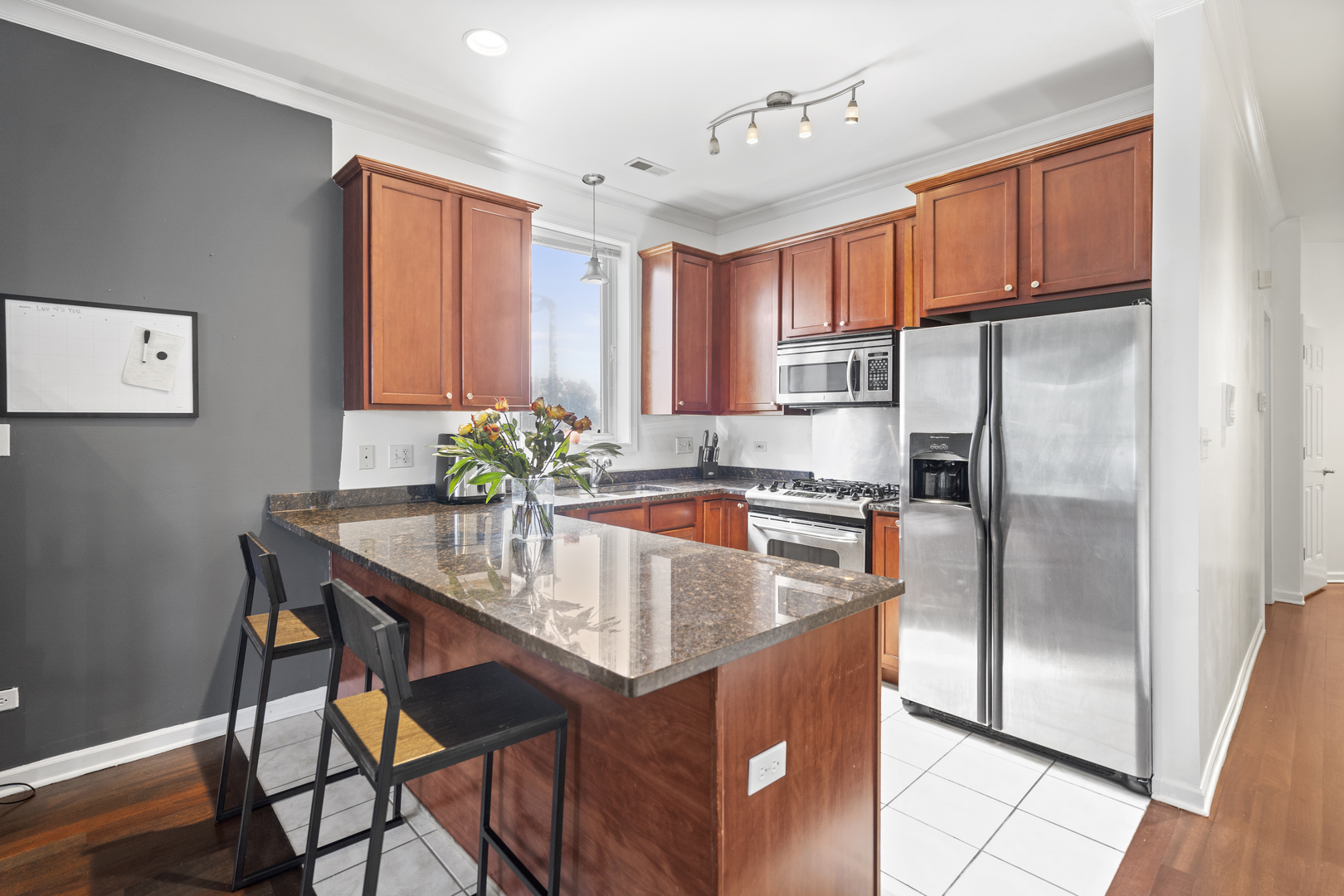 2539 West Warren Boulevard, Unit 2 Chicago, IL 60612 - Photo 4 of 14 a kitchen with stainless steel appliances granite countertop a refrigerator a sink and a stove with wooden floors
