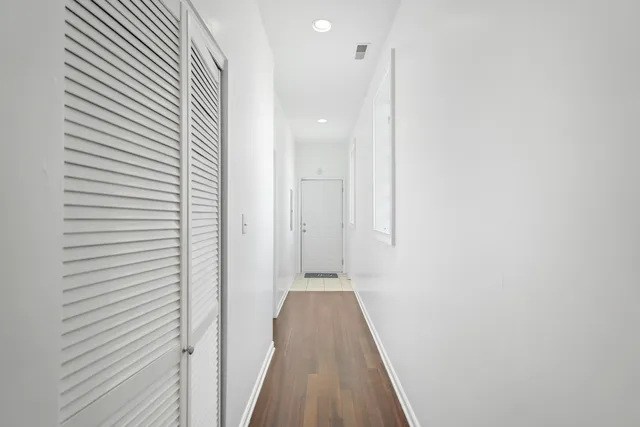 a view of a hallway with wooden floor