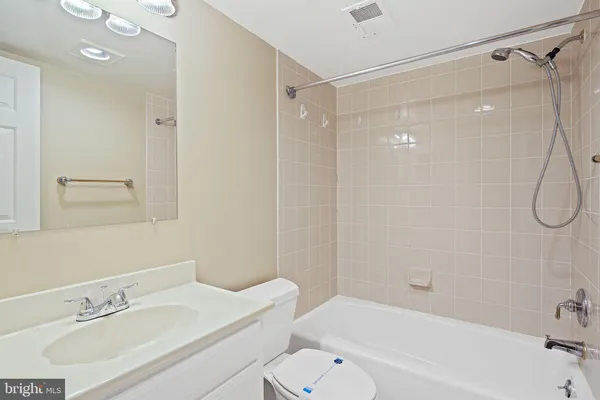 a bathroom with a bathtub shower sink vanity and toilet