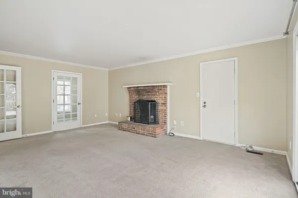 an empty room with windows and fireplace