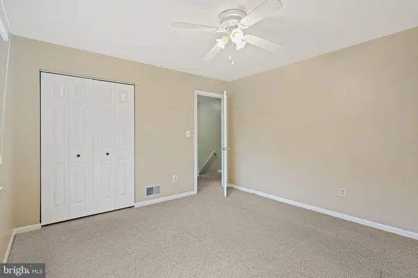 an empty room with a ceiling fan and a window