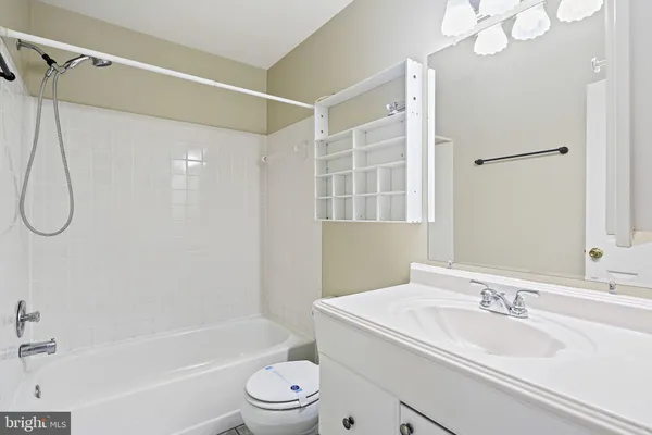a bathroom with a granite countertop sink a toilet and shower