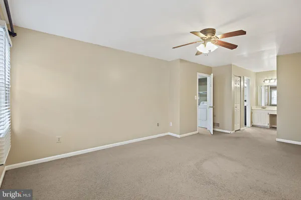 an empty room with chandelier fan