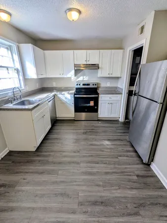 a kitchen with granite countertop a refrigerator and a sink