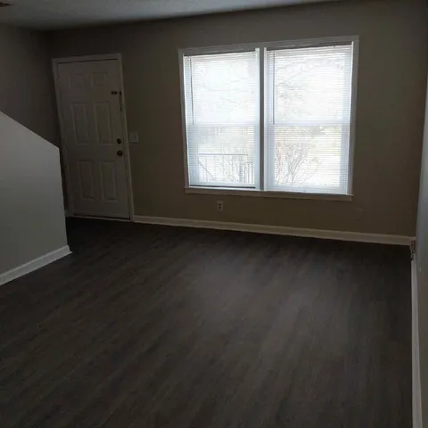 a view of a livingroom with wooden floor and a window