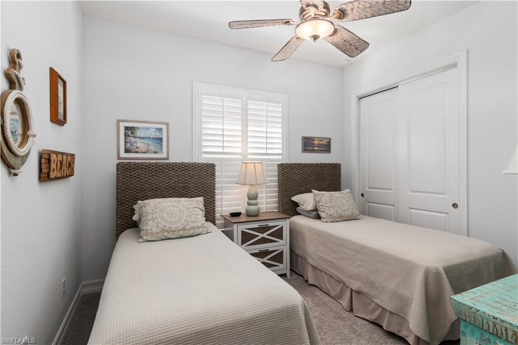 6604 Roma Way Naples, FL 34113 - Photo 10 of 21 a bedroom with two beds and a chandelier