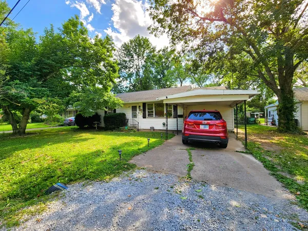 a view of a car parked in a yard with a house