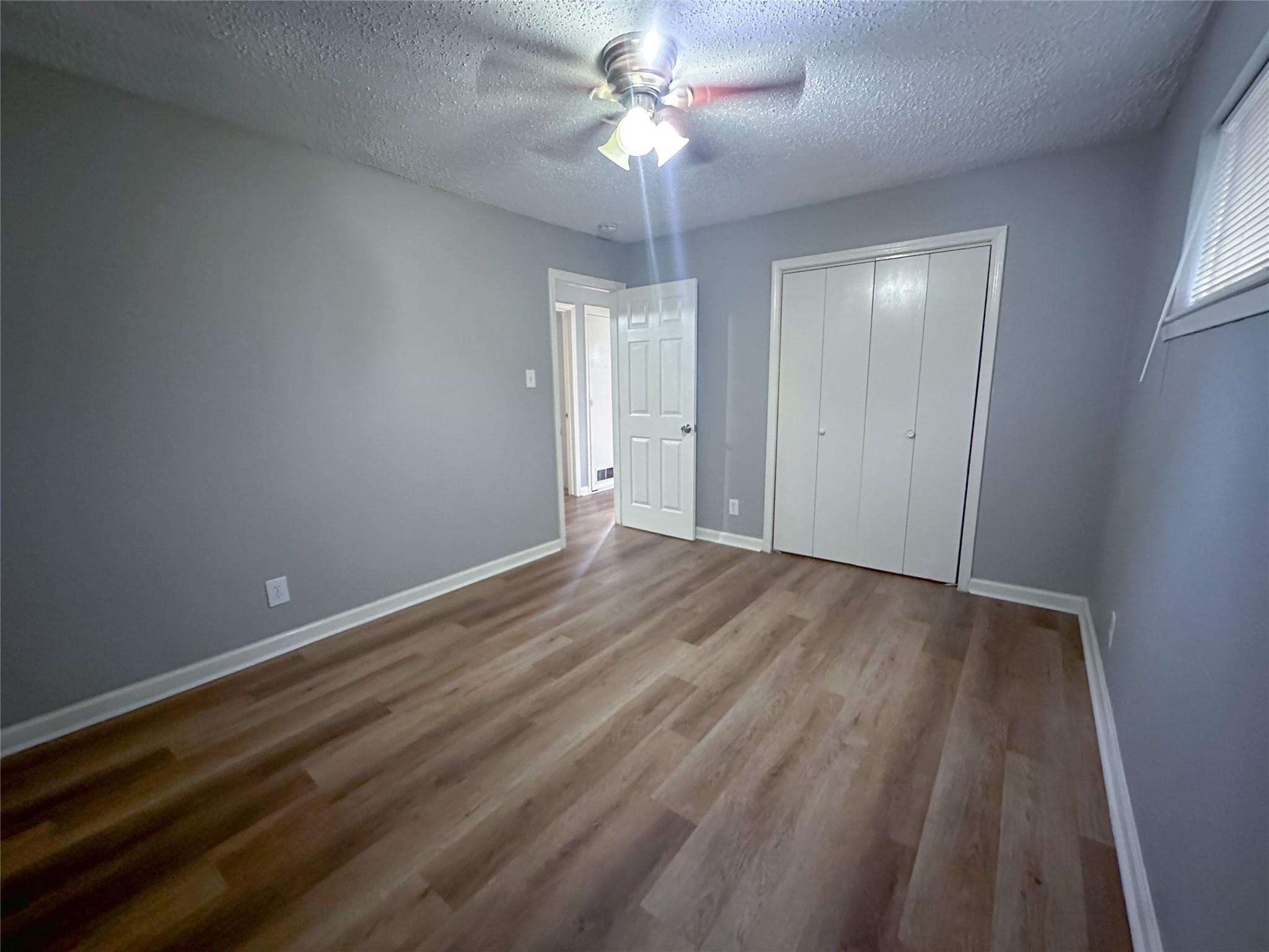 5418 Weaver Road, Unit A Houston, TX 77016 - Photo 5 of 9 wooden floor in an empty room with a window