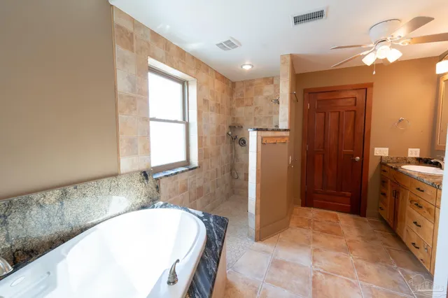 a bathroom with a tub sink and mirror