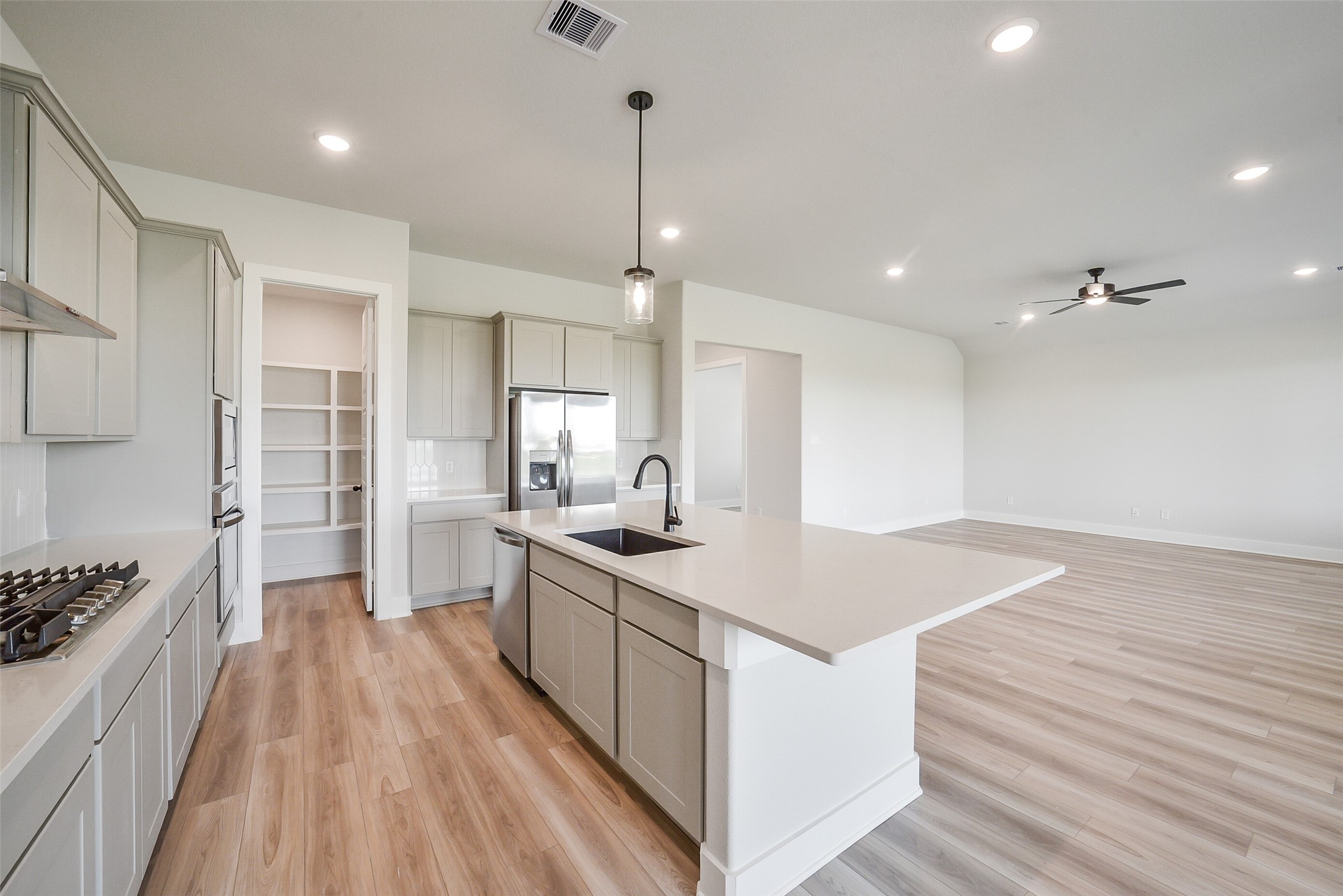 1831 Tioga Vw Drive Rosharon, TX 77583 - Photo 20 of 50 a open kitchen with kitchen island a sink stove and wooden floor
