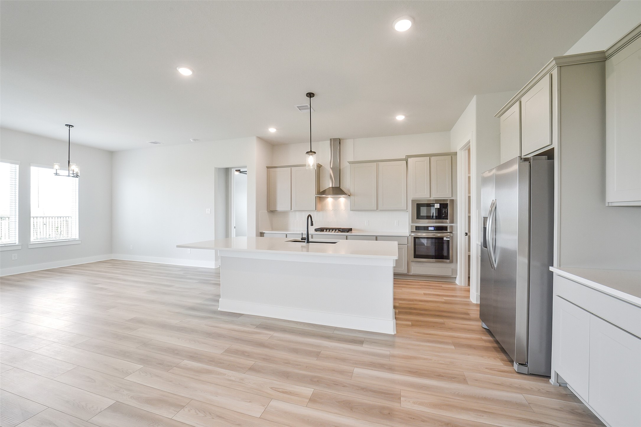 1831 Tioga Vw Drive Rosharon, TX 77583 - Photo 26 of 50 a kitchen with stainless steel appliances kitchen island granite countertop a refrigerator a sink dishwasher a oven and a dining table with wooden floor