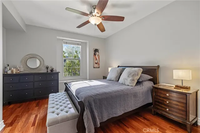 a spacious bedroom with a bed and wooden floor