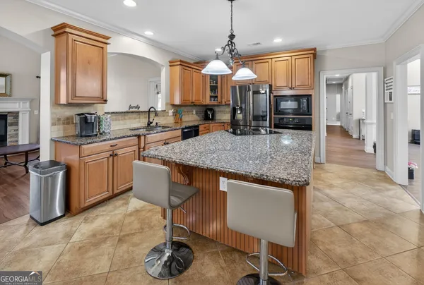 a kitchen with stainless steel appliances granite countertop a stove top oven a sink a counter space and cabinets