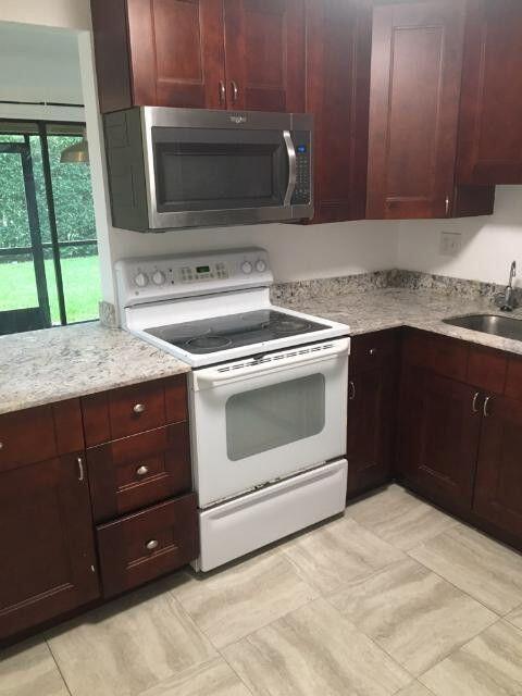 1189 Northwest 13th Street, Unit 7 Boca Raton, FL 33486 - Photo 13 of 15 a kitchen with a stove and a microwave