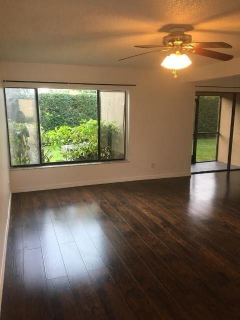 1189 Northwest 13th Street, Unit 7 Boca Raton, FL 33486 - Photo 15 of 15 a view of empty room with wooden floor and fan