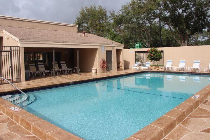 1189 Northwest 13th Street, Unit 7 Boca Raton, FL 33486 - Photo 2 of 15 a view of a patio with table and chairs with wooden floor and fence