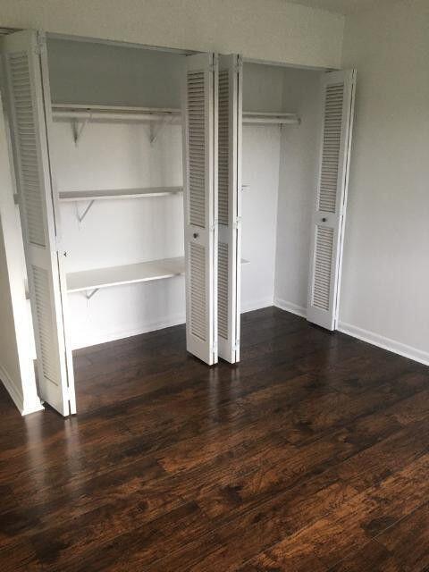 1189 Northwest 13th Street, Unit 7 Boca Raton, FL 33486 - Photo 4 of 15 a view of an empty room with wooden floor and windows