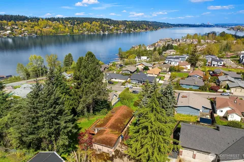 an aerial view of a residential houses with outdoor space and lake view