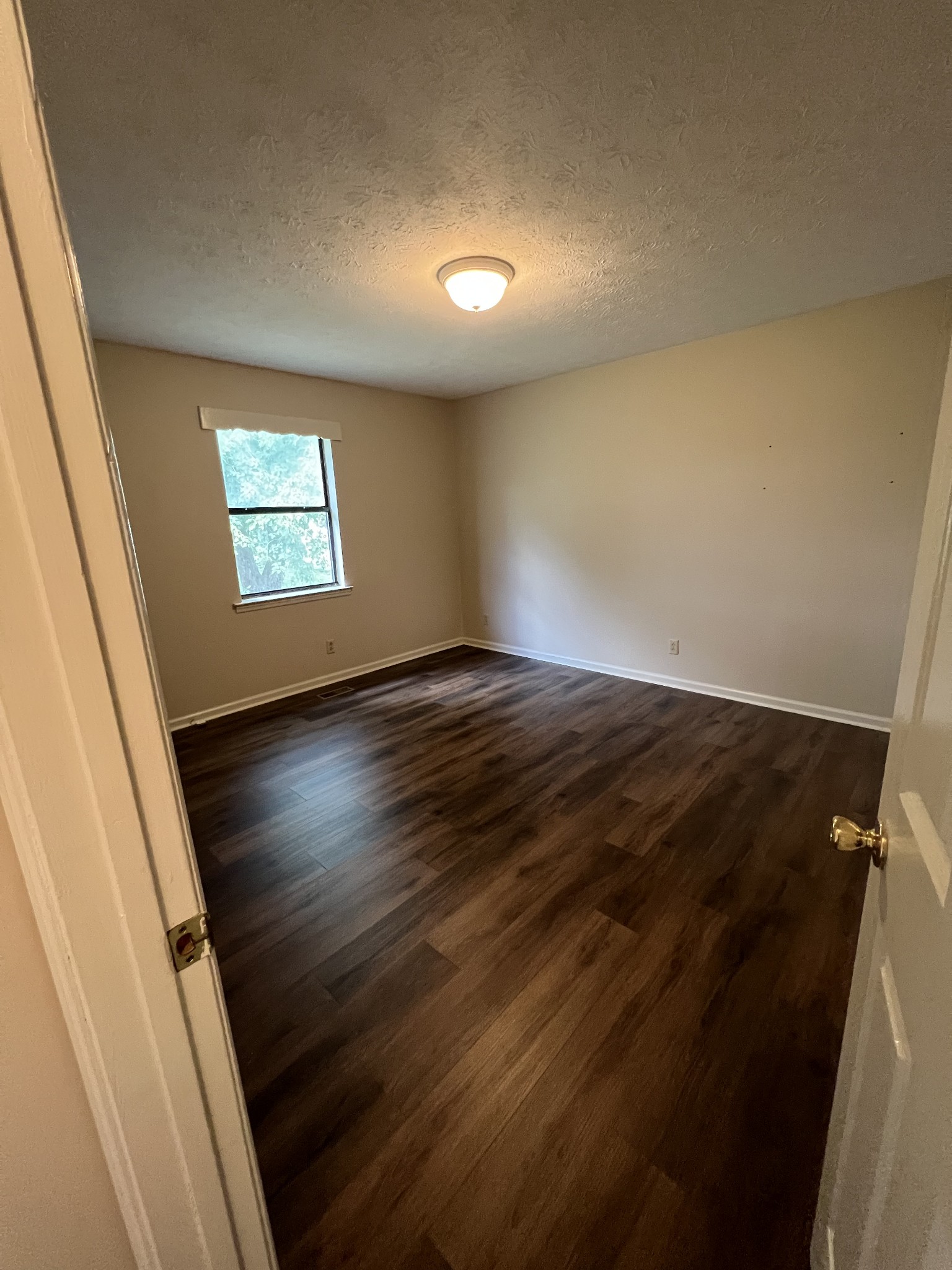 5012 Jacksboro Road Morrison, TN 37357 - Photo 9 of 13 an empty room with wooden floor and windows