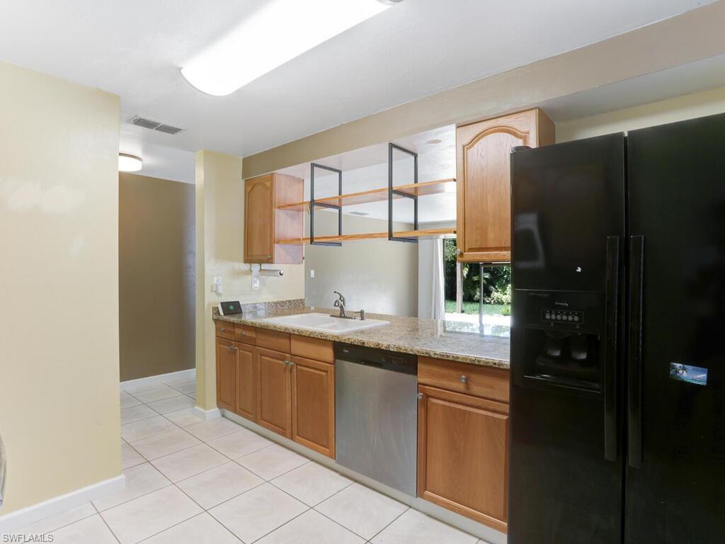 9101 Hamlin Road West Fort Myers, FL 33967 - Photo 9 of 24 a kitchen with a sink and refrigerator