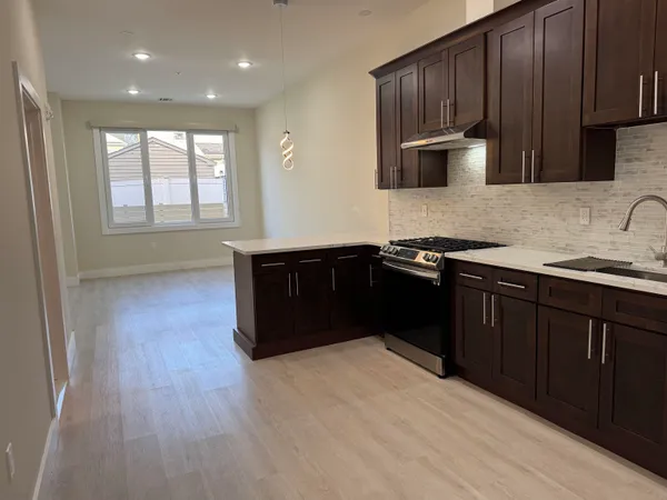 a kitchen with stainless steel appliances granite countertop wooden cabinets a refrigerator and a sink