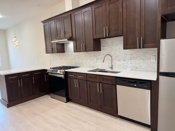 a kitchen with granite countertop a refrigerator and a sink