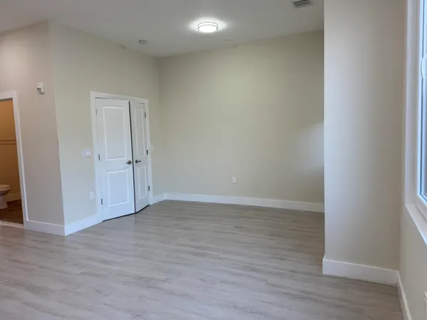 a view of an empty room with wooden floor