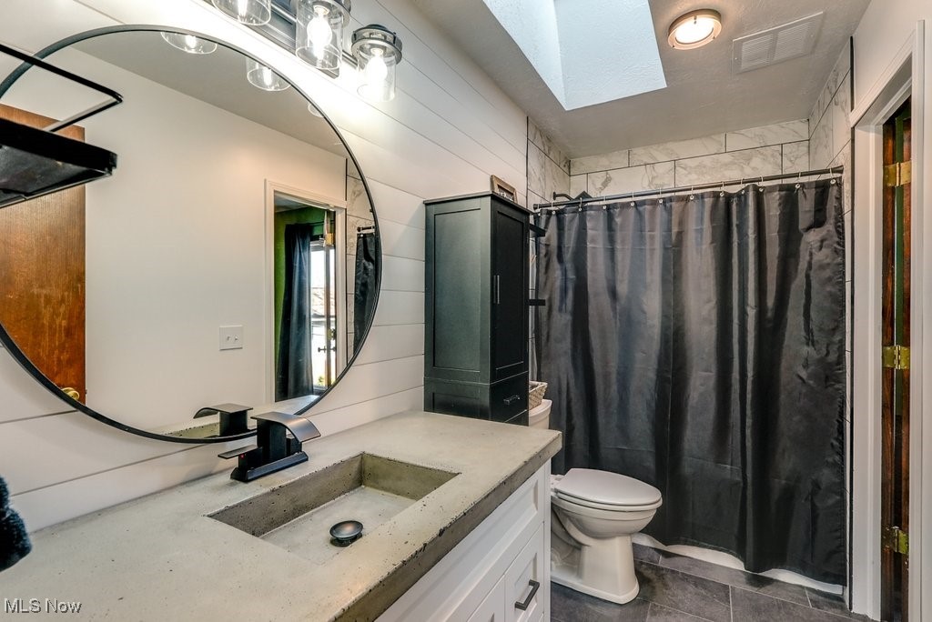 1157 Bass Circle Northwest Canton, OH 44708 - Photo 13 of 31 Full bath with visible vents, toilet, a shower with curtain, a skylight, and vanity