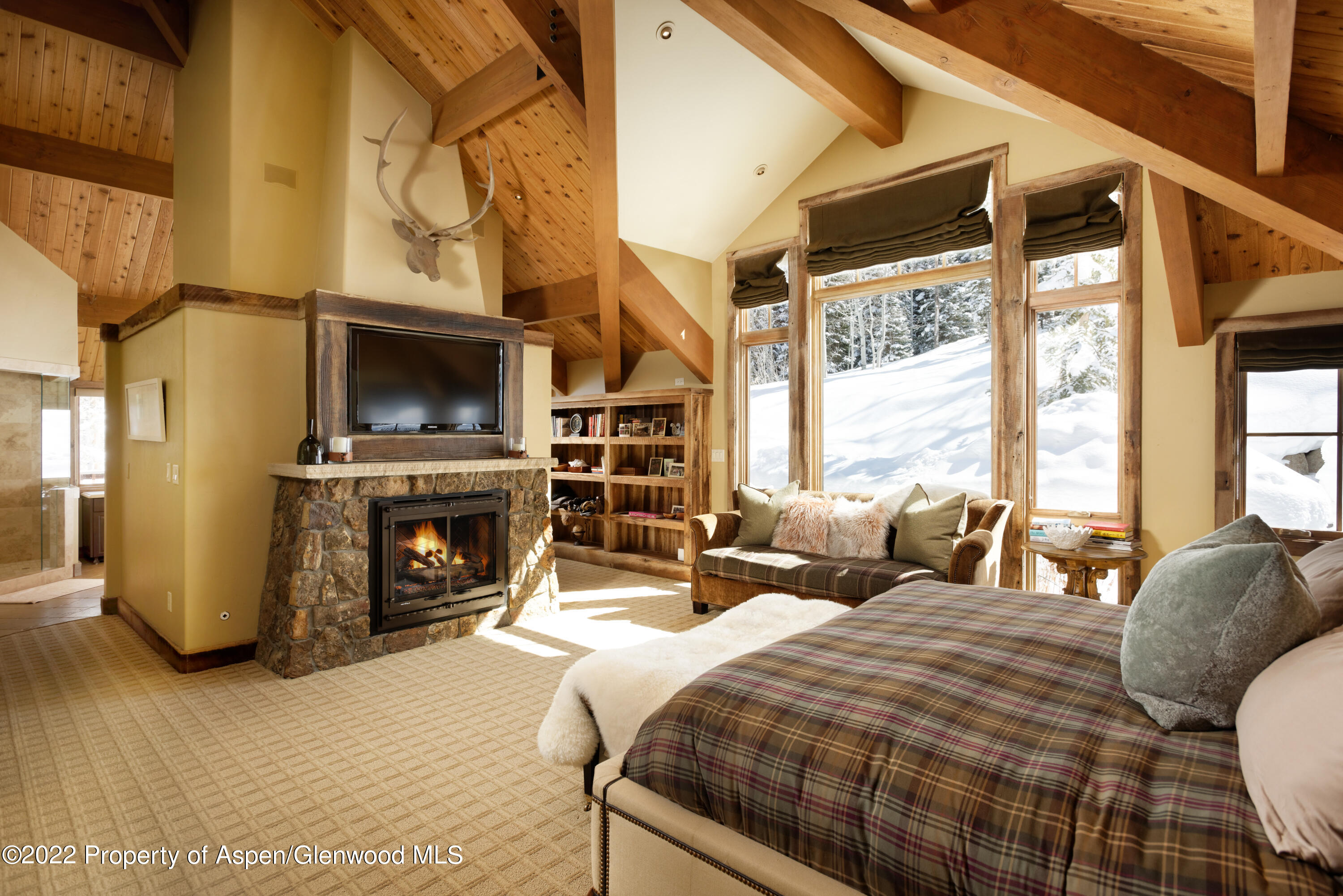 1400 Wood Road Snowmass Village, CO 81615 - Photo 12 of 36 a bedroom with bed a flat tv screen and a fireplace