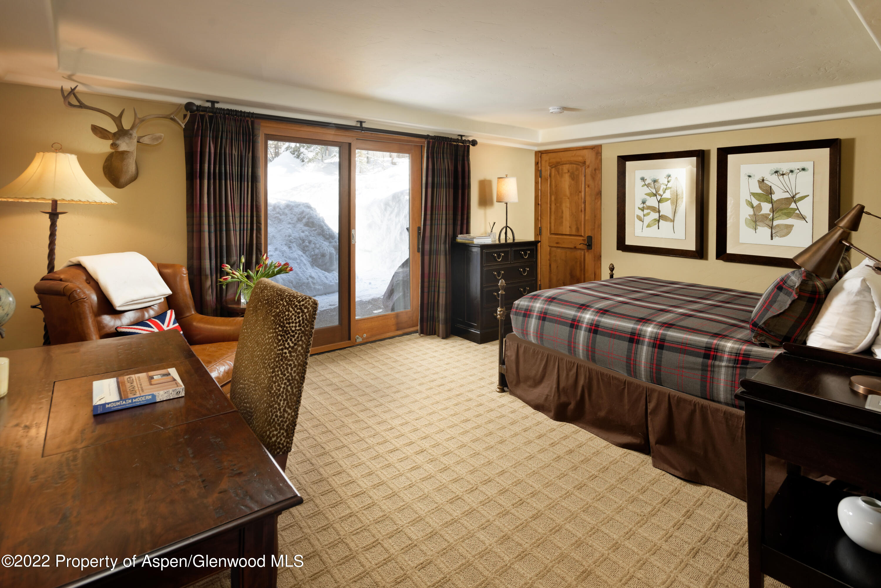 1400 Wood Road Snowmass Village, CO 81615 - Photo 18 of 36 a bedroom with a bed a bookshelf and a large window