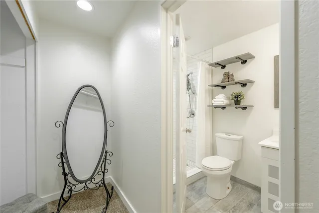 a bathroom with a toilet and a shower