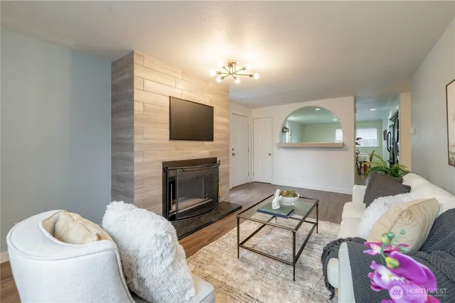 a living room with furniture a flat screen tv and a fireplace