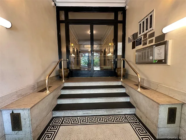 a view of staircase with lots of frames on wall and a window