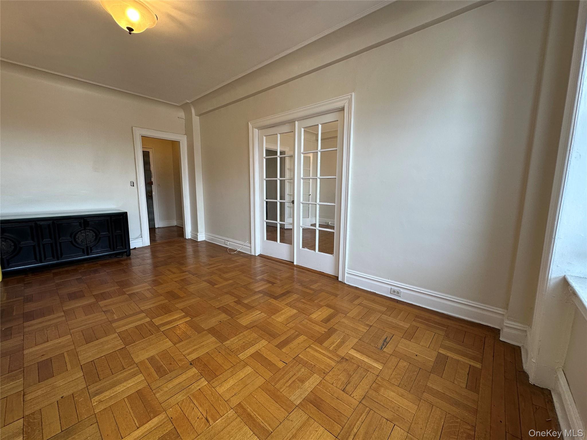 409 Edgecombe Avenue, Unit 7F Manhattan, NY 10032 - Photo 5 of 22 a view of an empty room with window and a kitchen