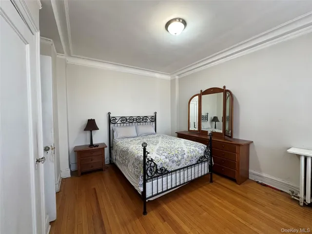 a bedroom with a bed lamp and wooden floor