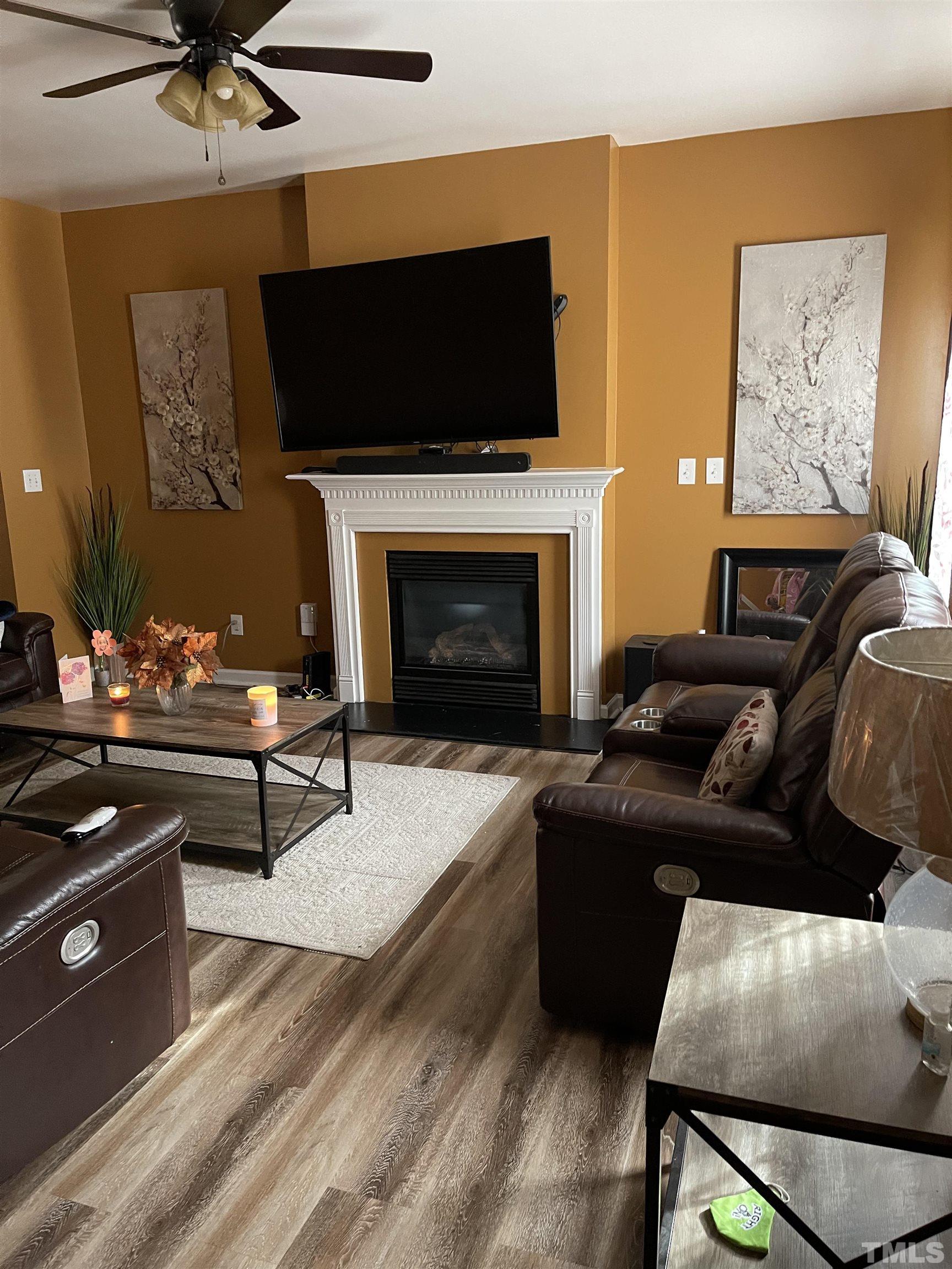 1109 Early Rise Street Raleigh, NC 27610 - Photo 3 of 16 a living room with furniture a flat screen tv and a fireplace